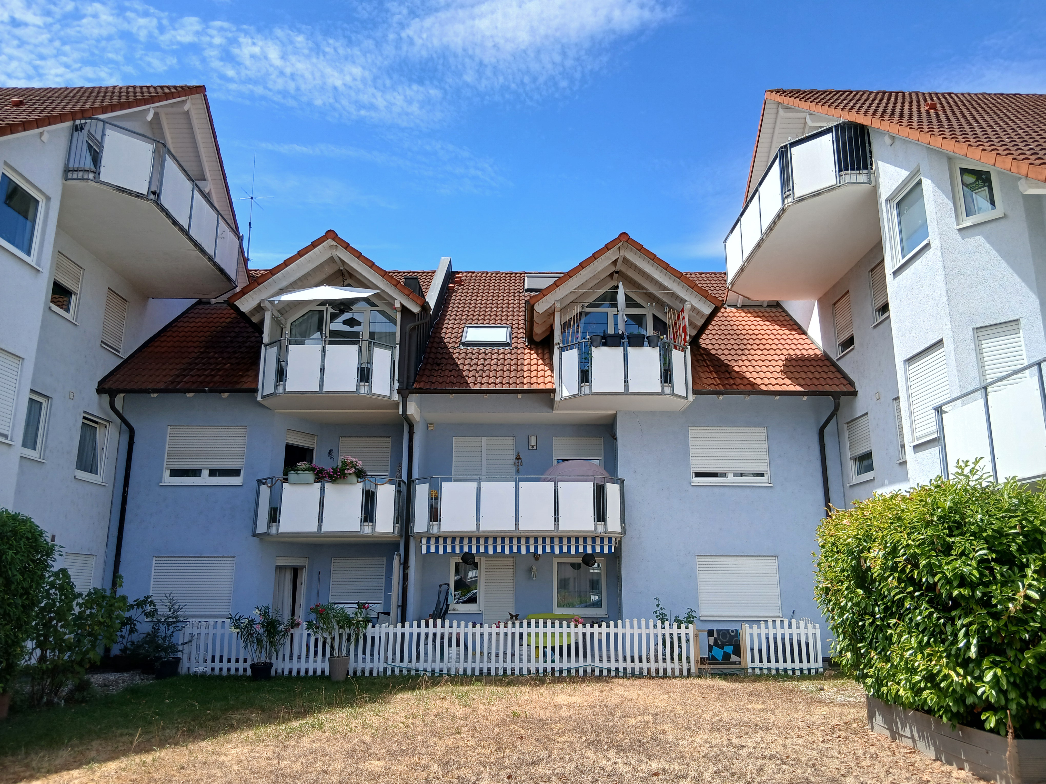 Rückseite eines Mehrfamilienhauses mit Balkonen nach der Sanierung